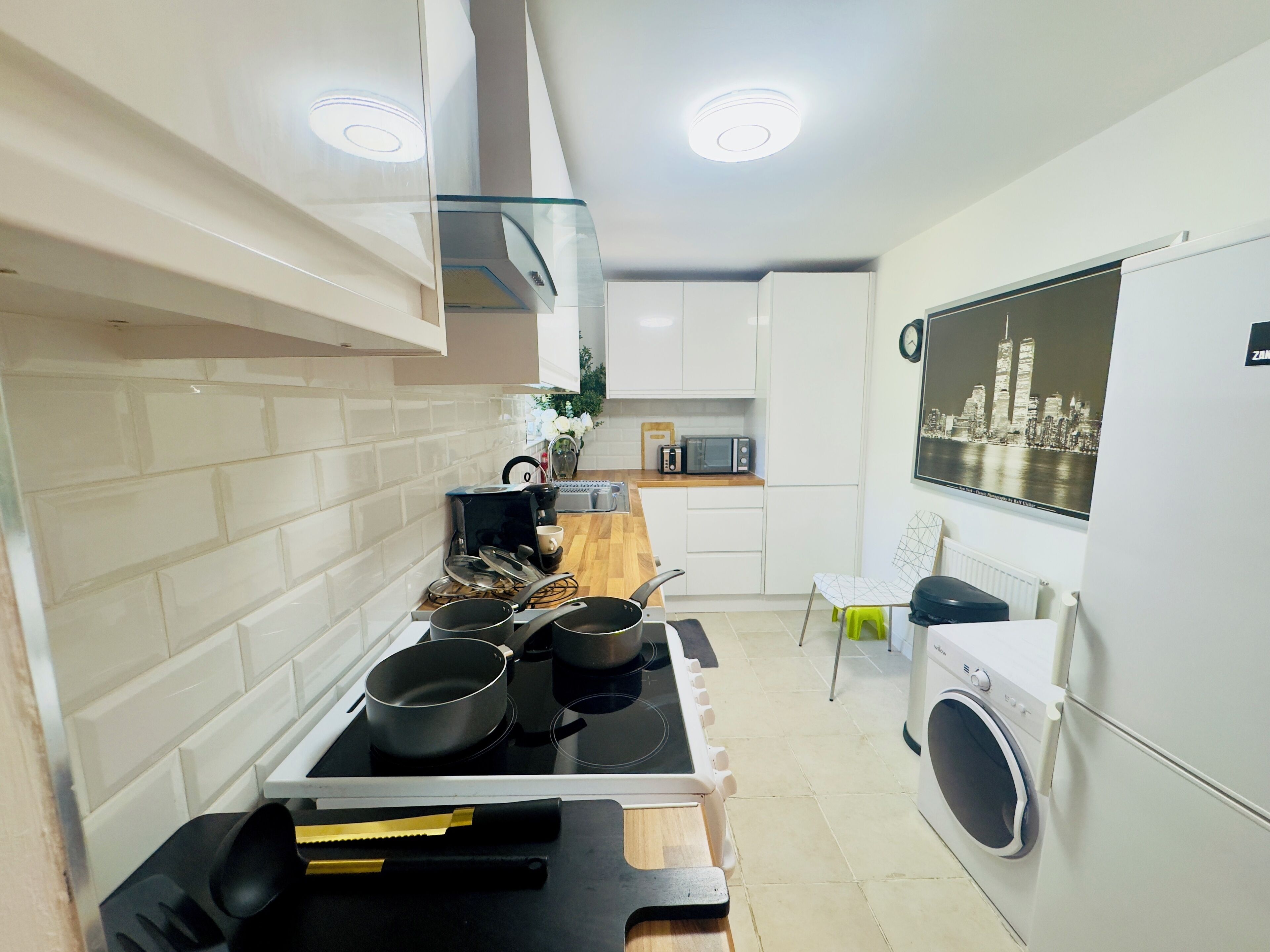A compact kitchen with a stove, microwave, and a washing machine.
