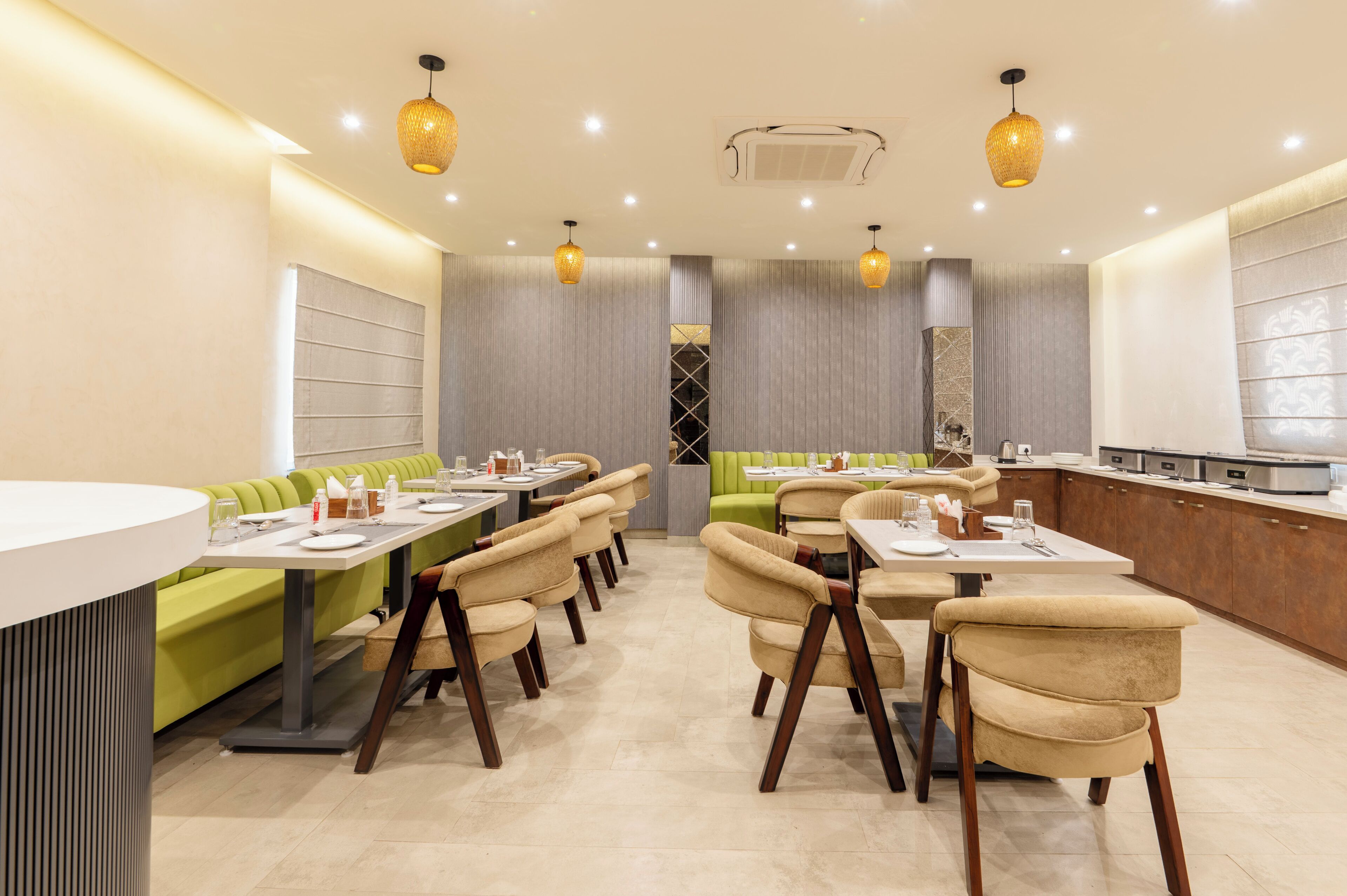 Een modern restaurant met afgesloten ruimtes, tafels, een bar en een centraal zitgedeelte.