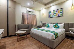 Una habitación de hotel moderna con cama, mesita de noche y una pequeña mesa redonda.