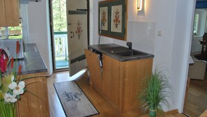 A kitchen with wooden cabinets, a built-in sink, and a door leading to a balcony.