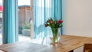 Una mesa de madera con un florero transparente que contiene flores.