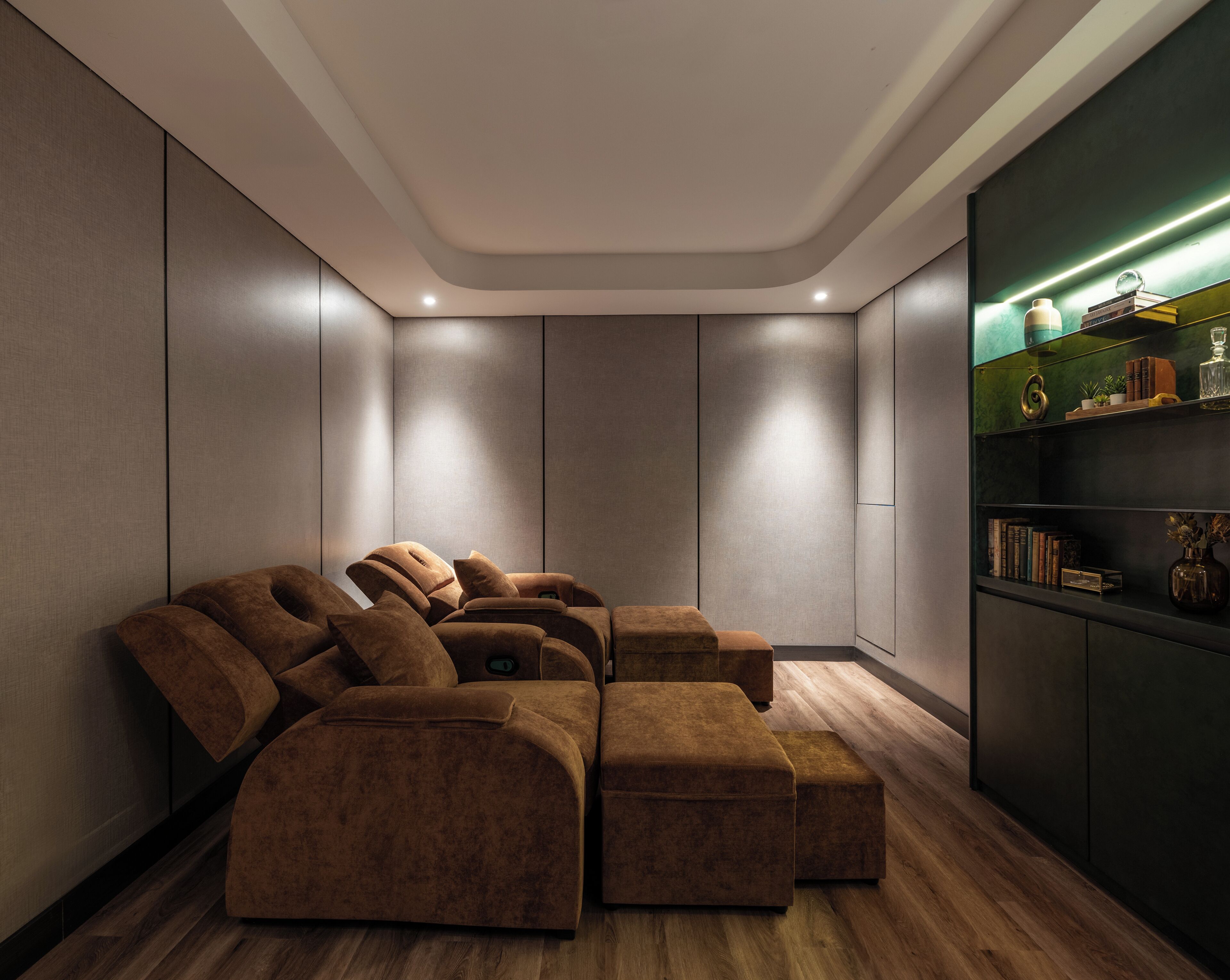 A modern room with a sectional sofa, built-in shelving with books and decorative items, and a wooden floor.