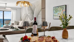 A dining table with a wine bottle, glasses, and a charcuterie board with fruits and meats.