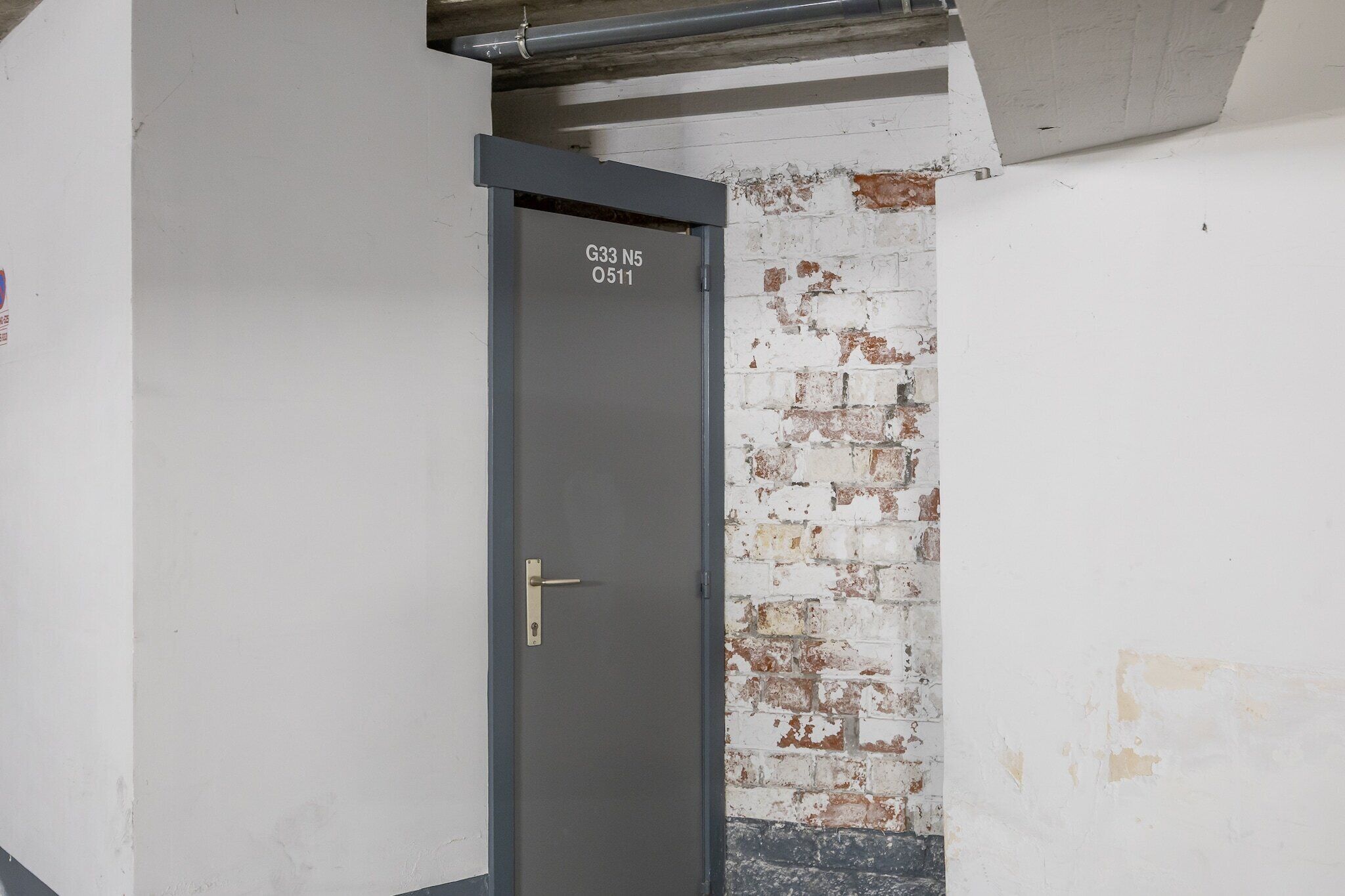 A closed door with a metal handle and a label reading "G33 N5 0511".