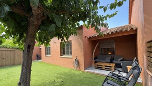Un patio con un sofá, sillas y una mesa.