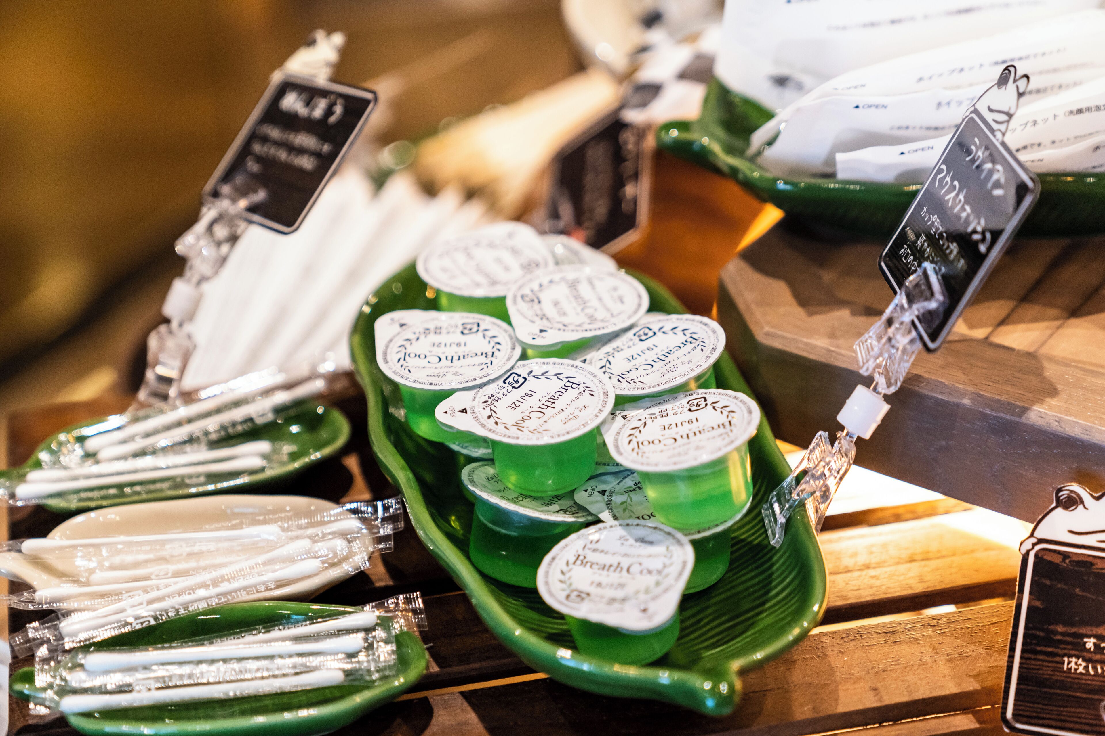 A display of green trays with multiple containers, each labeled with text.