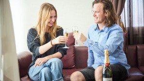 Two people sitting on a leather couch, holding glasses of champagne. - Hotel BaliAn Resort - Shinjuku Forest (Tokyo)