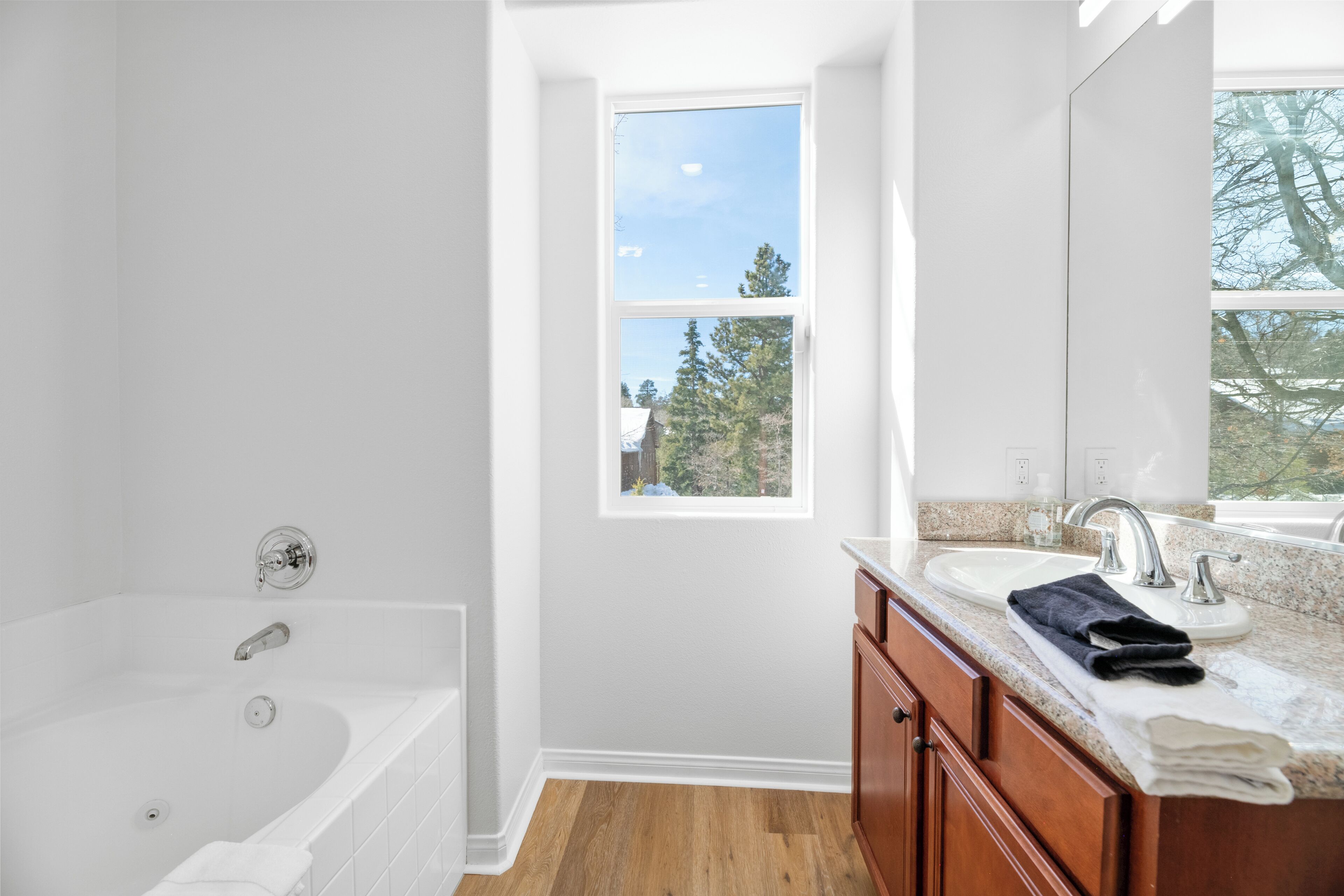 A modern bathroom with a bathtub, sink, and vanity.