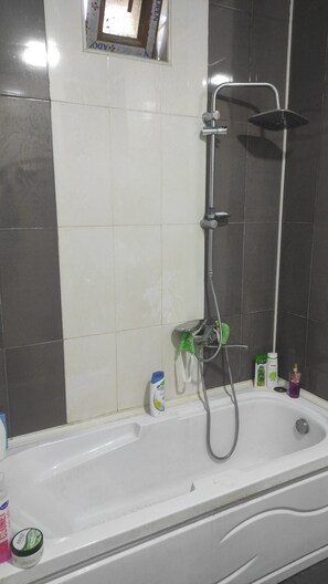 Une salle de bain avec une baignoire, une douche et des toilettes.