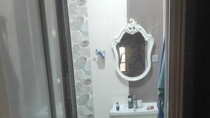 A bathroom with a white sink, a mirror, and a toilet.