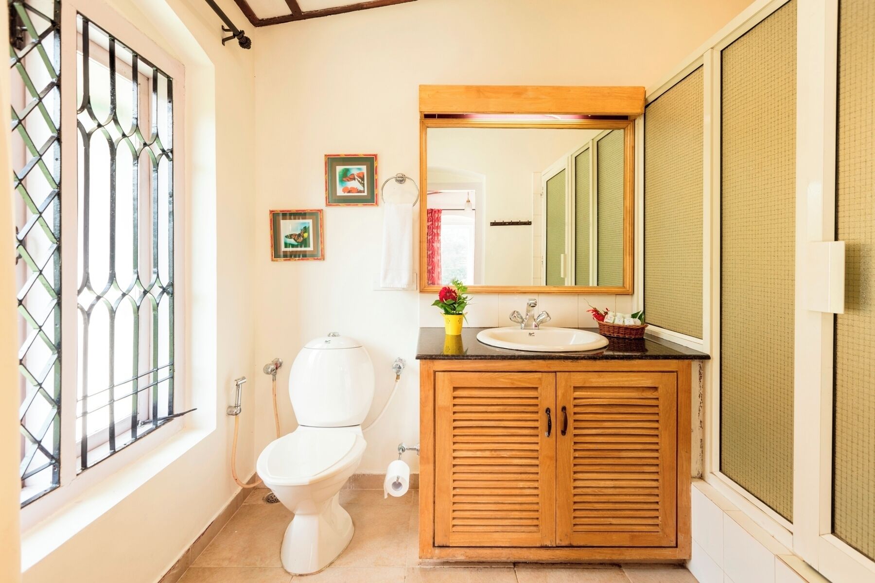 Ein Badezimmer mit Toilette, Waschbecken, Holzschrank und Spiegel.