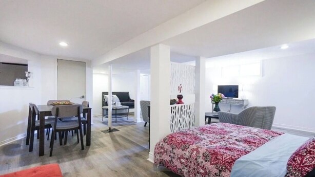 Una habitación de hotel moderna con una cama, un escritorio y un comedor.