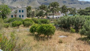 Paisagem montanhosa com edifícios, árvores e céu limpo.