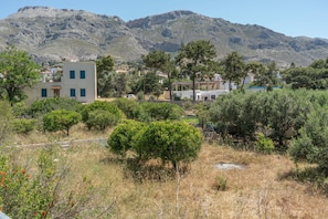 A mountainous landscape with buildings, trees, and a clear sky.