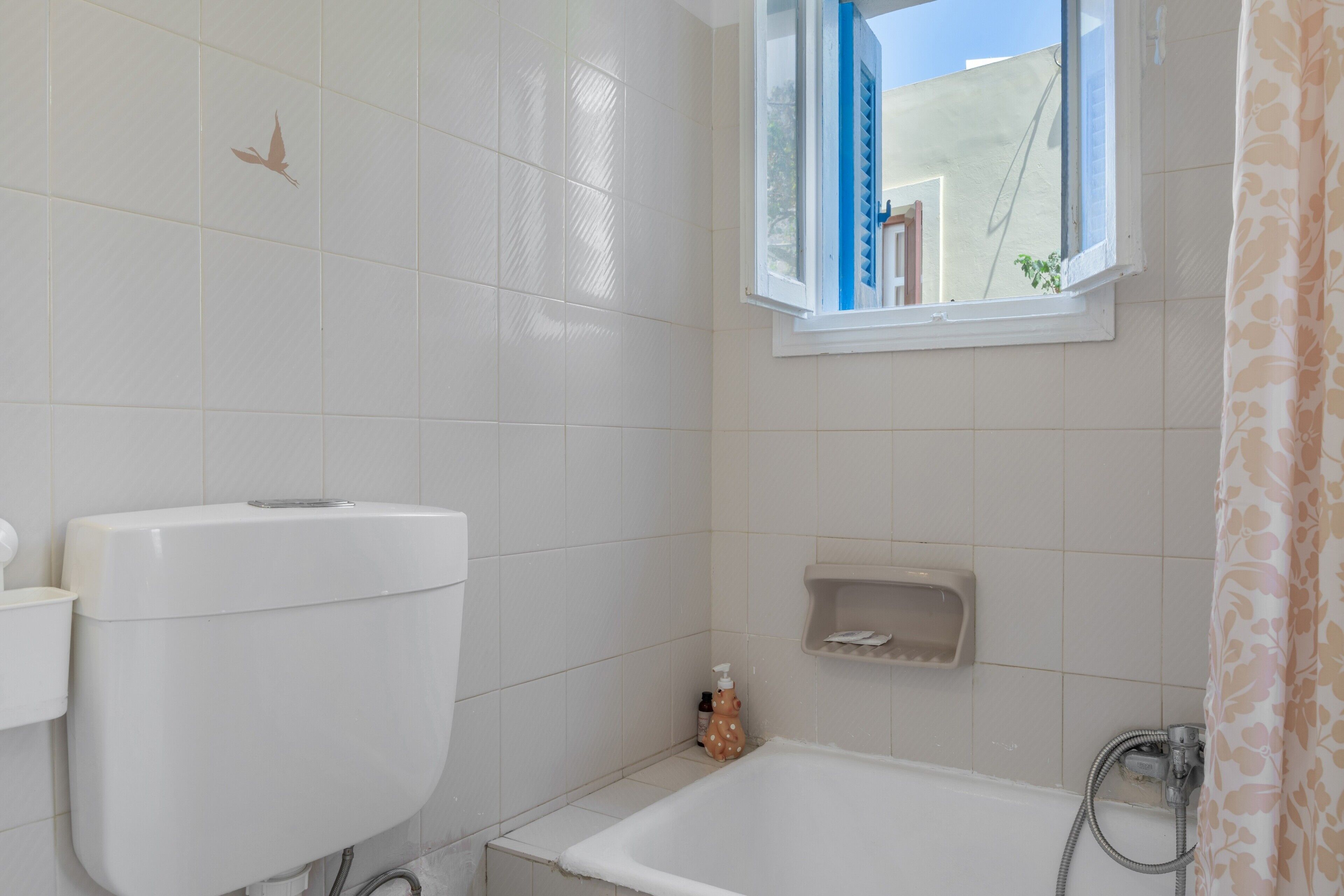 Ein Badezimmer mit Toilette, Badewanne, Fenster und Dusche.