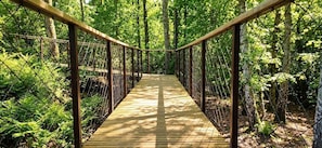 A wooden suspension bridge in a forested area with chain-link railings. - Gîte Hydra Charme & Nature for 4 People near Honfleur (CONTEVILLE)