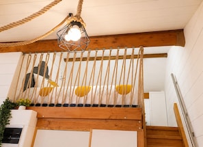 A wooden staircase with a rope barrier, a hanging light fixture, and a plant on the left. - Gîte Hydra Charme & Nature for 4 People near Honfleur (CONTEVILLE)