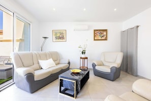 Un salon moderne avec un canapé, un fauteuil et une table basse.