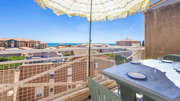 A balcony with a table, chairs, and an umbrella. - La Parenthese au Sud · Valras'Loc (Valras-Plage)