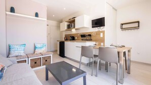 A modern apartment with a living area, a dining table, and a kitchen.