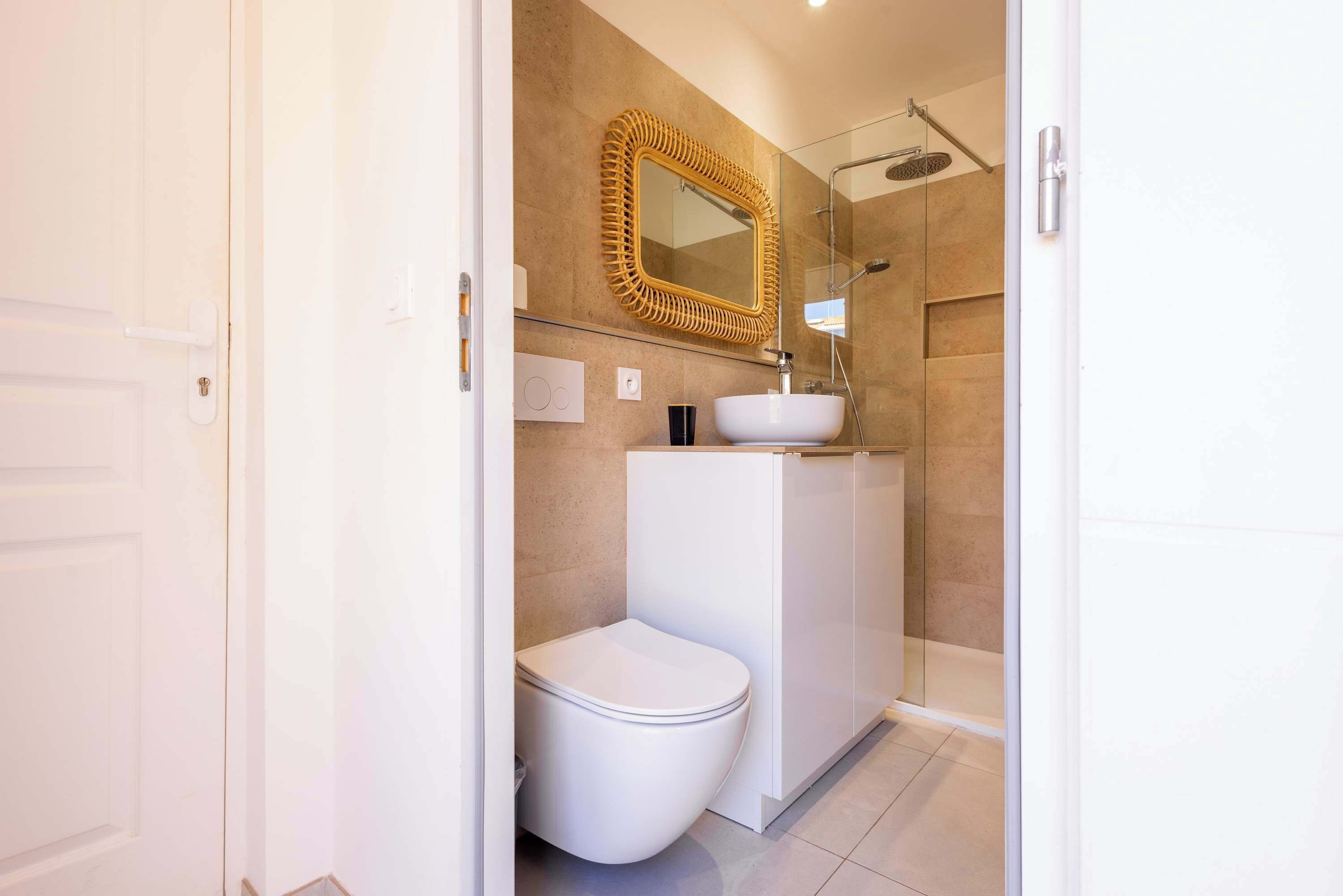 A bathroom with a toilet, sink, and shower.
