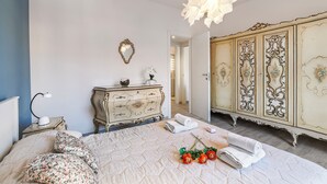A bedroom with a bed, a dresser, a mirror, and a chandelier. - Incanto Del Lago 50m to Lake Maggiore (Baveno)