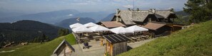 A mountain lodge with outdoor seating and a view of the surrounding mountains. - Mobile Home in Bodensdorf by Lake Ossiach (Steindorf am Ossiacher See)