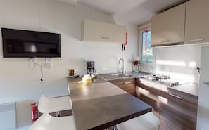 Una cucina moderna con una TV a schermo piatto, una macchina da caffè e una finestra vista panoramica.