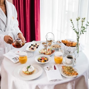 A breakfast setting with a variety of dishes, including toast, fruit, and pastries, on a table with a white tablecloth. - Venus Hotel Pristina (PRISTINA)