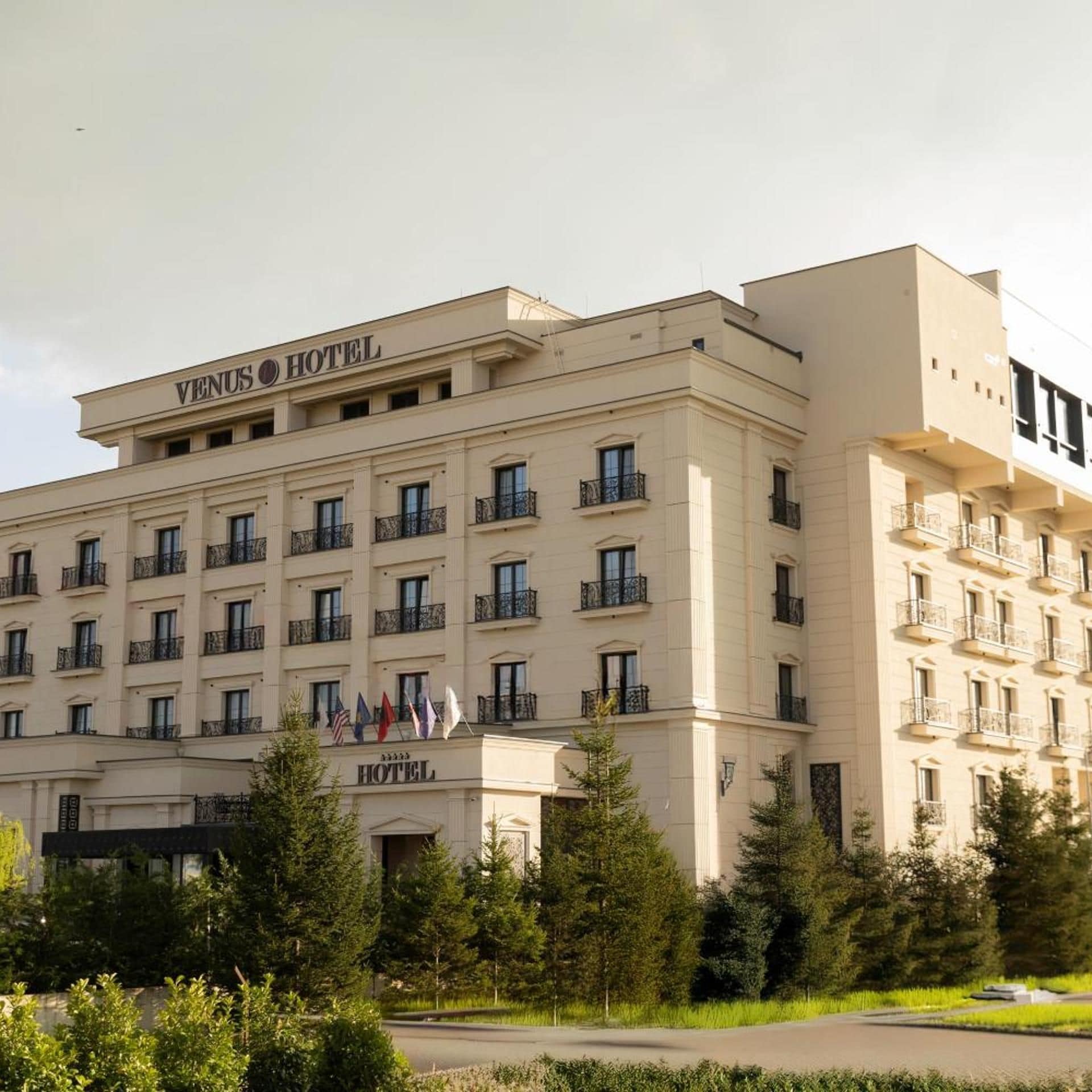 Un hotel de varios pisos con un estilo arquitectónico clásico, con balcones y una entrada central.
