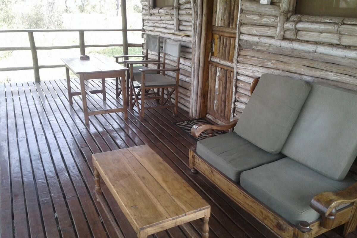 Eine Holzterrasse mit einer Couch und einem kleinen Tisch.
