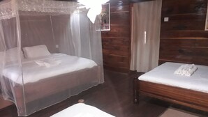 Une chambre avec deux lits, dont l’un est à baldaquin et l’autre ne l’est pas.
