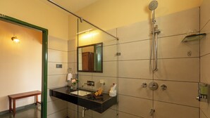 A modern bathroom with a glass shower enclosure, a black countertop sink, and a wooden bench. - Solitude by Nature Resorts and Stays (Kotagiri)