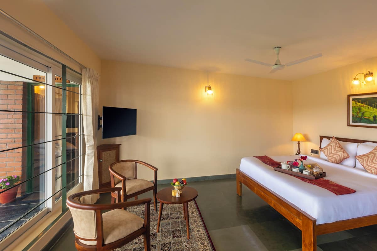 A hotel room with a bed, a desk with a chair, a television, and a window with a view of the outside.