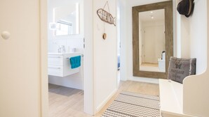 Een moderne badkamer met een wit wastafelmeubel, een blauwe handdoek en een spiegel.