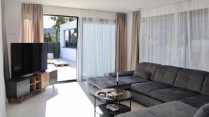 Una sala de estar moderna con un sofá gris, un televisor de pantalla plana y una mesa de centro.