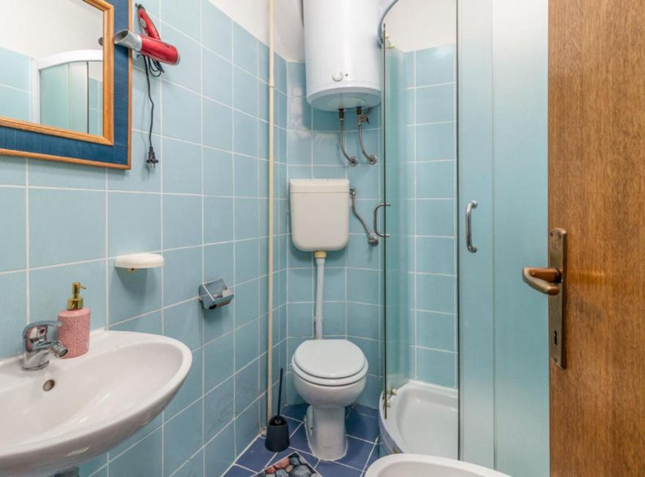 A bathroom with a sink, toilet, and shower.
