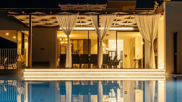 A modern hotel with a pool reflecting the building's interior. - Luxury Villa Lara with Heated Pool, Hot-Tub and Sauna (Zmijavci)