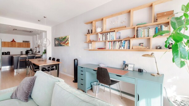 Un espacio habitable moderno con cocina, comedor y zona de trabajo con escritorio y silla.