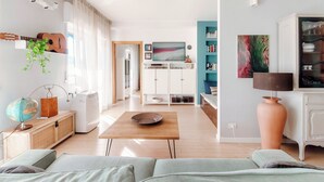 Una sala de estar moderna con un sofá, una mesa de centro, un globo terráqueo, una guitarra y un televisor.
