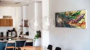 Una cocina moderna con comedor, que incluye una mesa de madera, sillas y una lámpara colgante.