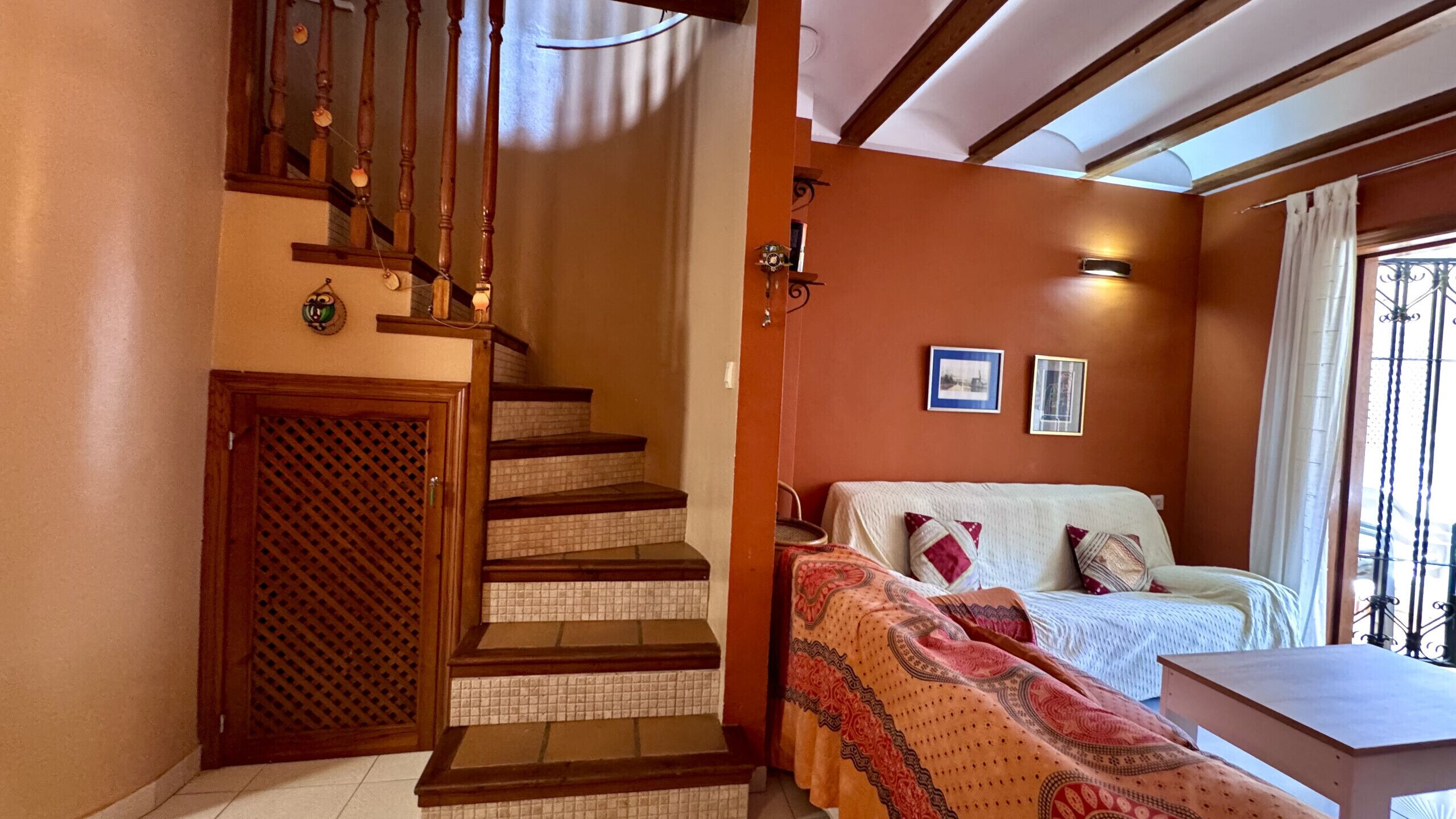Een slaapkamer met een bed, een houten trap en een kleine tafel.