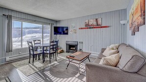 Una sala de estar con chimenea, televisor y sofá.