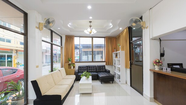 A modern living room with a sofa, a coffee table, and a reception desk. - Sabai Stay (Hua Hin)