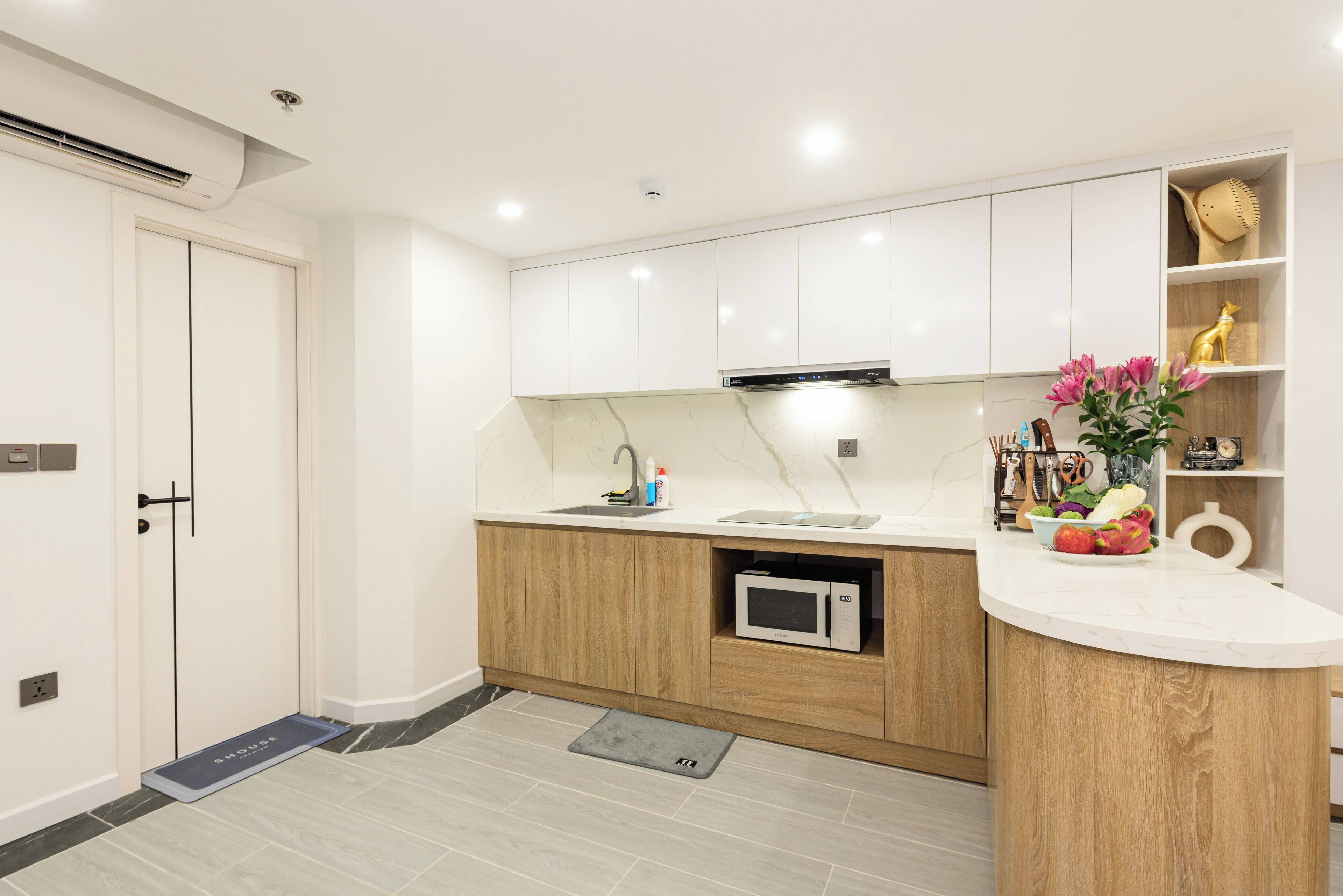 A modern kitchen with white cabinets, a built-in microwave, and a sink.