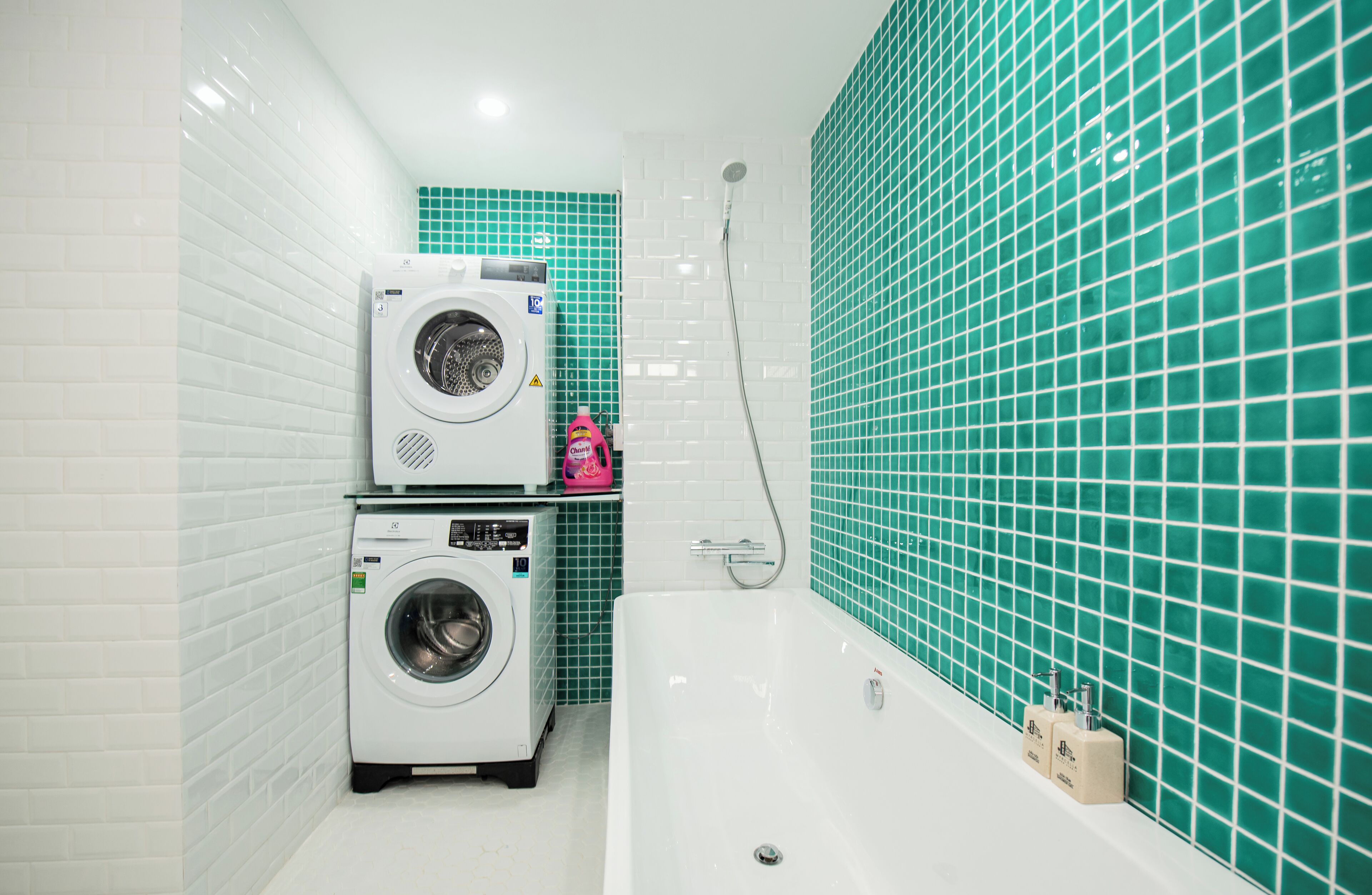 A bathroom with a washing machine, a bathtub, and a shower.