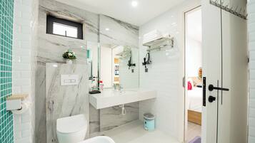 Ein modernes Badezimmer mit einem мраморной Waschbecken, einer Toilette und einer Badewanne.