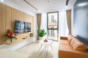 Leilighet – deluxe | Oppholdsområde | En 60-tommers LED-TV med digitale kanaler samt PC-skjermer og printere