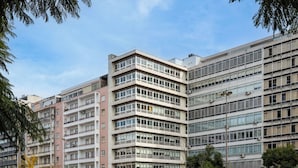 A multi-story building with a modern architectural style, featuring a mix of balconies and large windows.