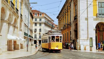 A tram on a city street with buildings on either side.
